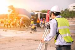 Surveyor engineers using an altometer at Construction Site.